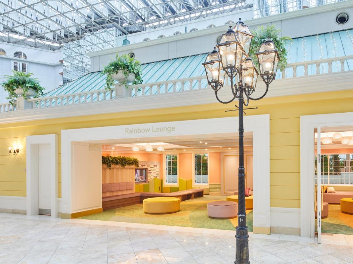 Отель Grand Nikko Tokyo Bay Maihama Ураясу Экстерьер фото The photo shows an indoor lounge area that features bright, pastel colors. The walls are painted yellow, and the entrance is framed with a clean, modern design. Inside the lounge, there are soft, rounded seating options in shades of pink and yellow, 