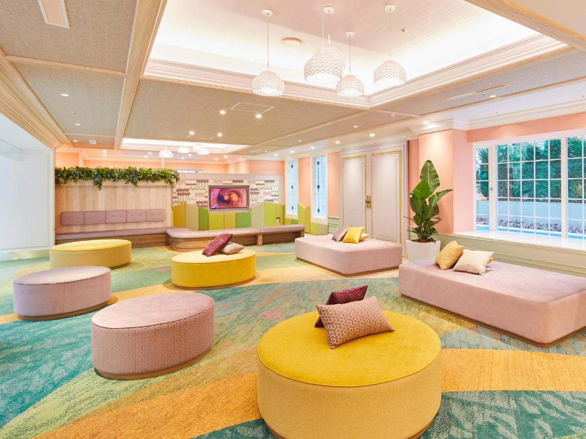 Отель Grand Nikko Tokyo Bay Maihama Ураясу Экстерьер фото The photo showcases a modern, brightly colored lounge area. The room features soft, rounded seating arrangements in vibrant shades of yellow, pink, and teal. The furnishings consist of low, cushioned stools or ottomans, with small decorative pillows 