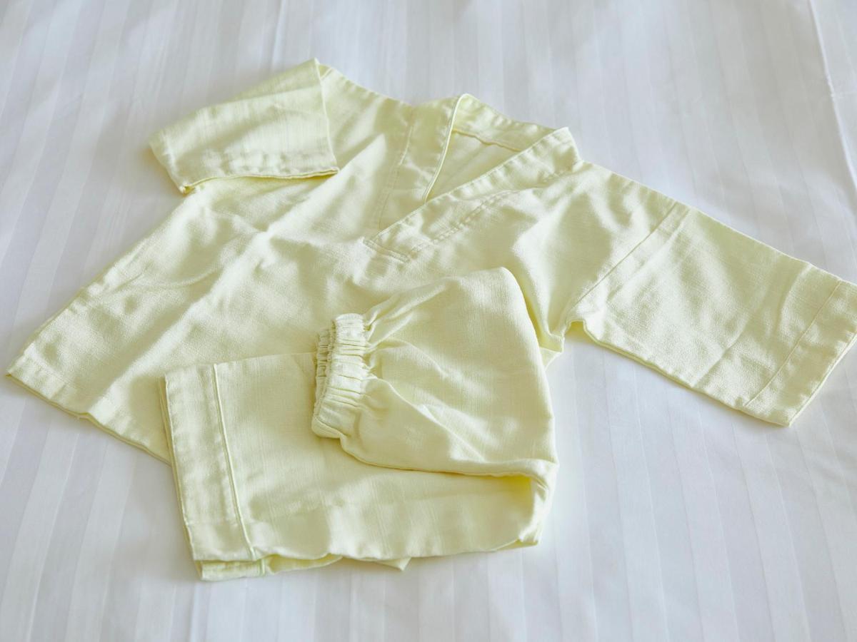 Отель Grand Nikko Tokyo Bay Maihama Ураясу Экстерьер фото The photo shows a small, traditional outfit made of light yellow fabric. The outfit includes a short-sleeved top with a V-neck and a pair of matching pants. The design is simple, featuring a loose fit and a comfortable style, making it suitable for c