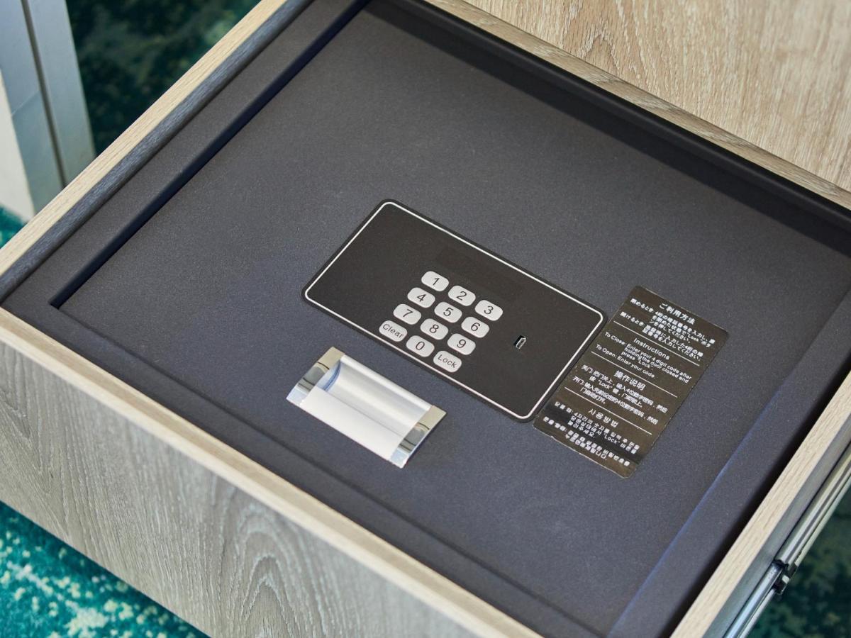 Отель Grand Nikko Tokyo Bay Maihama Ураясу Экстерьер фото The photo shows a small safe that is installed in a drawer. Inside the safe, there is a digital keypad with numeric buttons for entering a code. Next to the keypad, there appears to be a small manual or instruction card. The interior of the safe is l