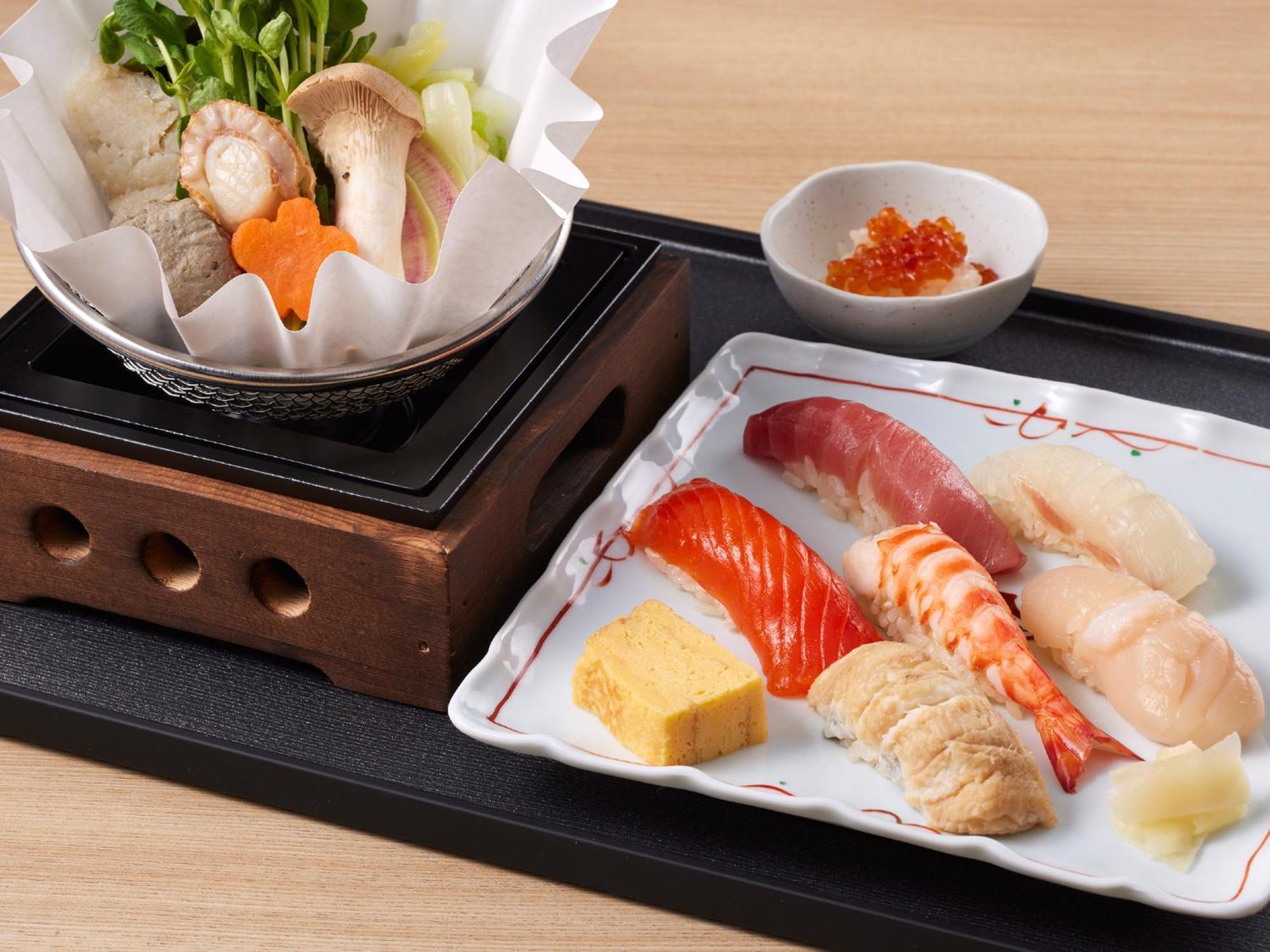 Отель Grand Nikko Tokyo Bay Maihama Ураясу Экстерьер фото The photo features a Japanese meal presented on a wooden tray. On the left, there is a small pot with a clear broth containing vegetables, mushrooms, and possibly meat, indicated by green herbs and a piece shaped like a flower. On the right, there is